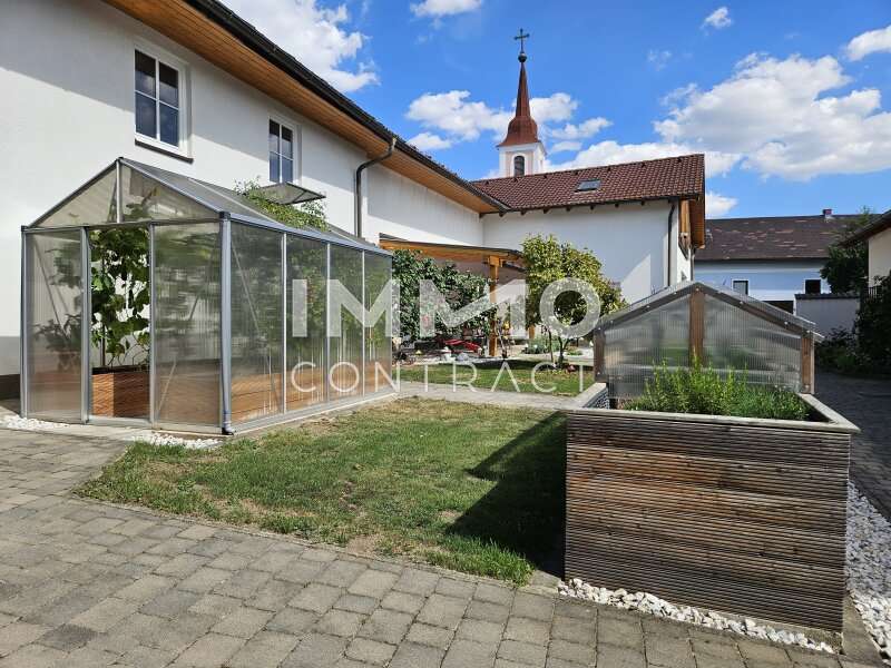 Innenhof mit Glashaus und Hochbeet