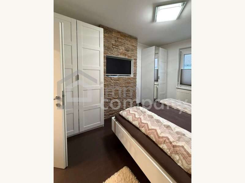 Schlafzimmer mit TV und Steindekor